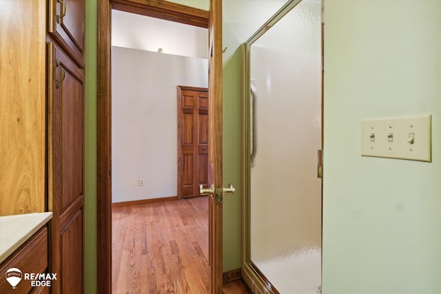 bathroom featuring vanity, wood-type flooring, and walk in shower