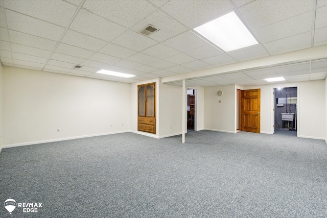 basement with carpet floors and a drop ceiling