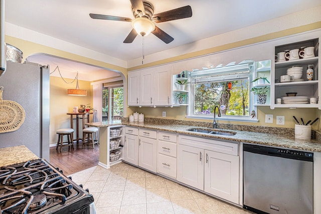 kitchen featuring light stone countertops, sink, stainless steel appliances, light hardwood / wood-style floors, and white cabinets