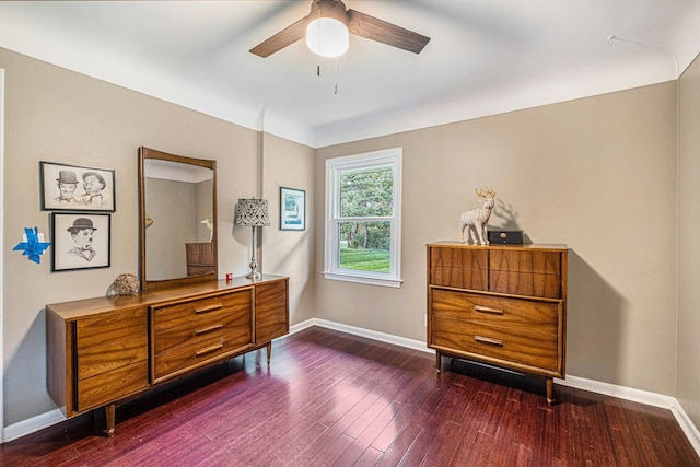 living area featuring ceiling fan and dark wood-type flooring