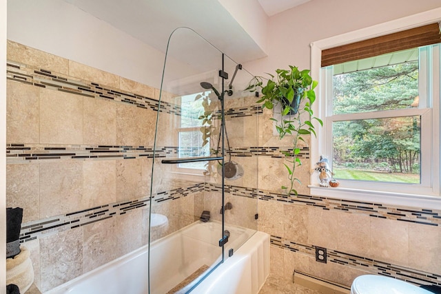 bathroom featuring a healthy amount of sunlight and shower / bath combination with glass door