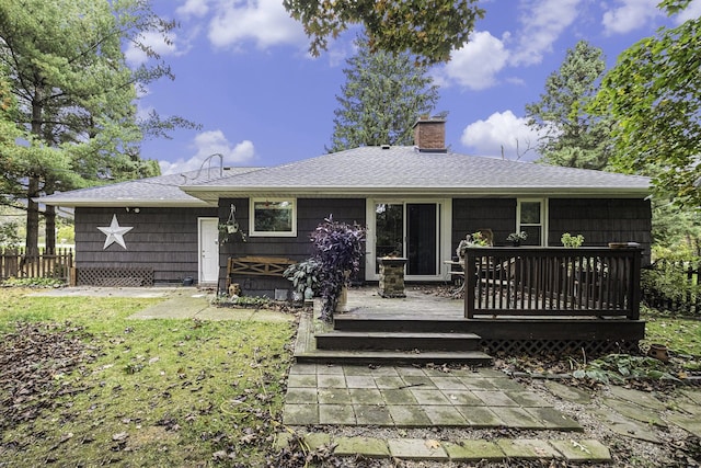 rear view of house featuring a lawn and a deck