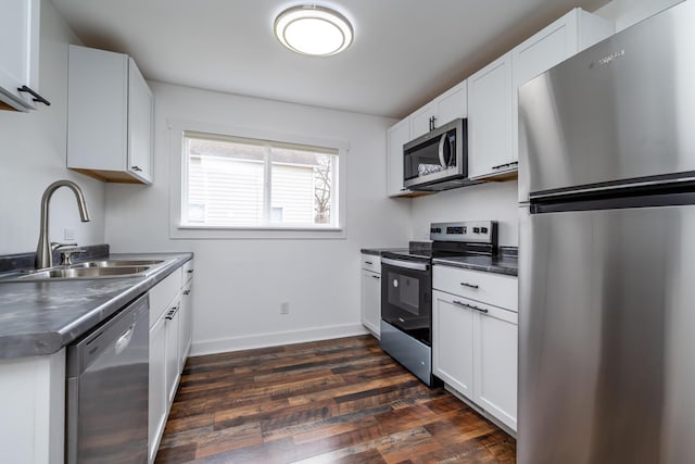 308 N Elm St, Three Oaks, MI 49128 - kitchen featuring stainless steel appliances, dark wood-type flooring, dark countertops, and white cabinets