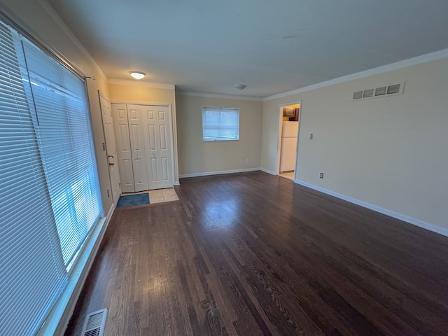 empty room featuring ornamental molding and dark hardwood / wood-style floors