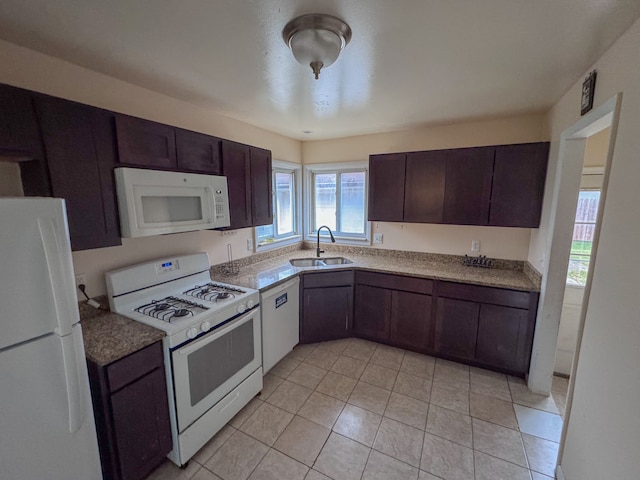 kitchen featuring sink, white appliances, dark brown cabinets, and light tile patterned floors