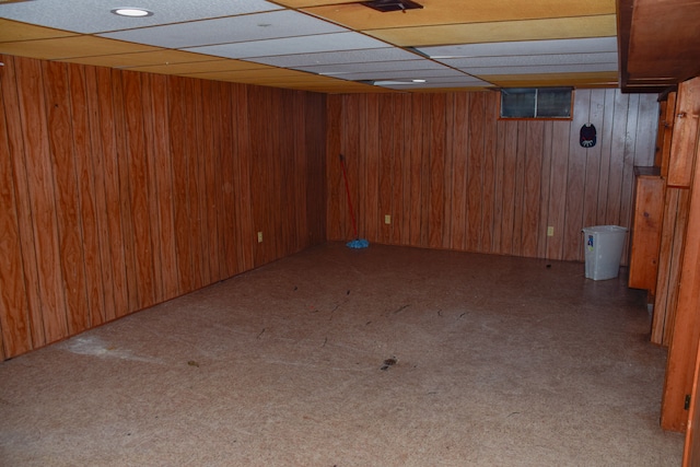 basement featuring carpet flooring and wooden walls