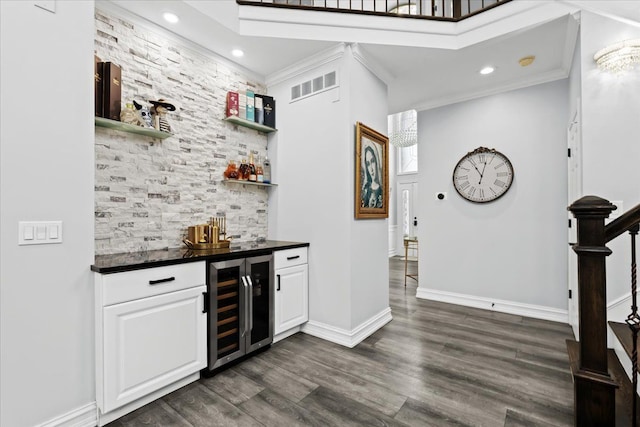 bar featuring dark hardwood / wood-style flooring, white cabinetry, wine cooler, and crown molding