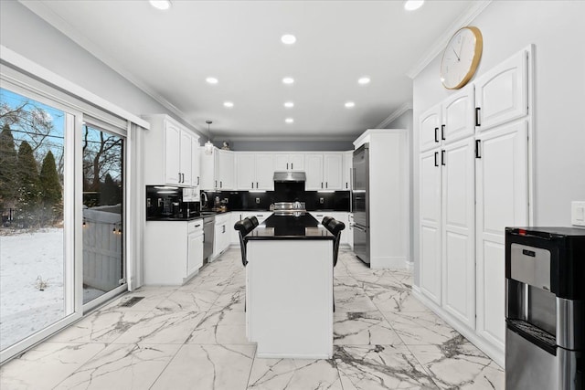 kitchen with white cabinets, tasteful backsplash, stainless steel dishwasher, and a kitchen island