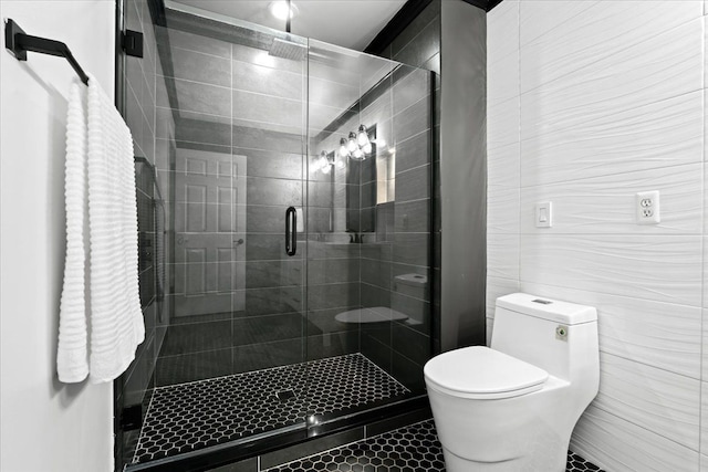 bathroom featuring a shower with door, tile walls, and toilet