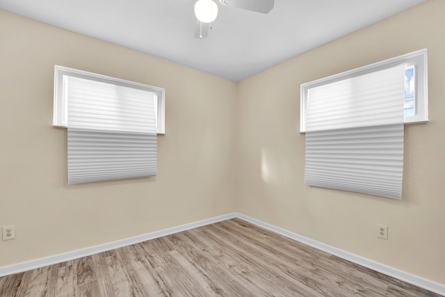 spare room featuring ceiling fan, a healthy amount of sunlight, and light wood-type flooring