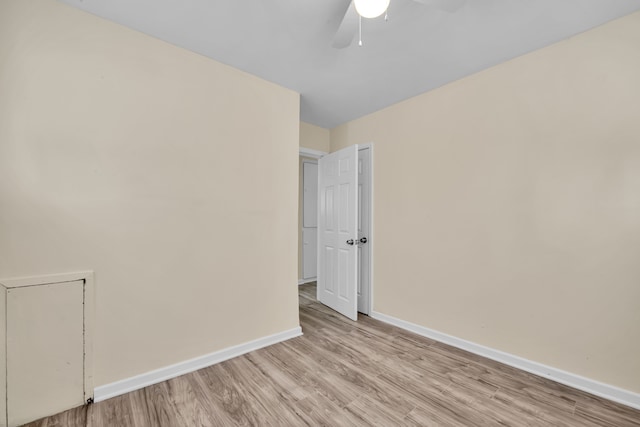 empty room with ceiling fan and light hardwood / wood-style flooring