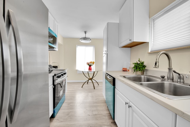 kitchen featuring white cabinets, sink, appliances with stainless steel finishes, and light hardwood / wood-style flooring