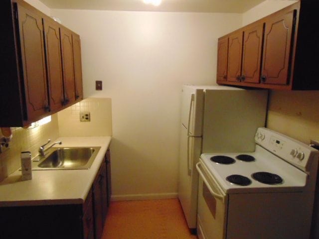 kitchen with white electric range, sink, and tasteful backsplash