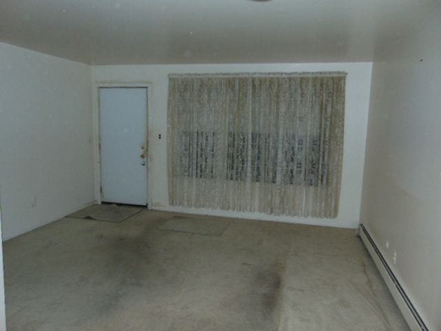 unfurnished room with a baseboard radiator