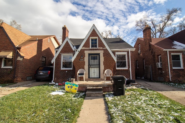 tudor-style house with a front lawn and cooling unit