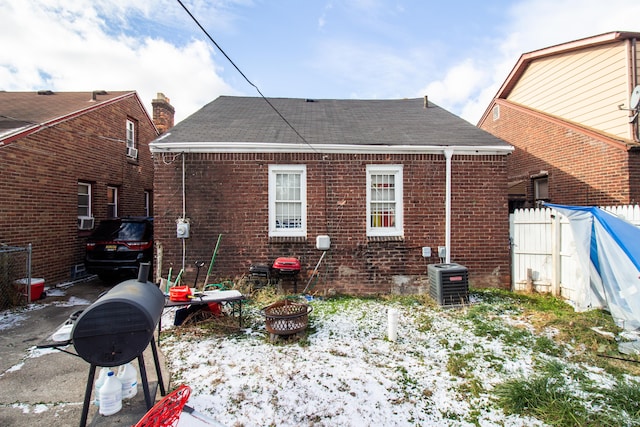 snow covered house with central AC