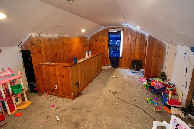 bonus room featuring lofted ceiling, light colored carpet, and wooden walls