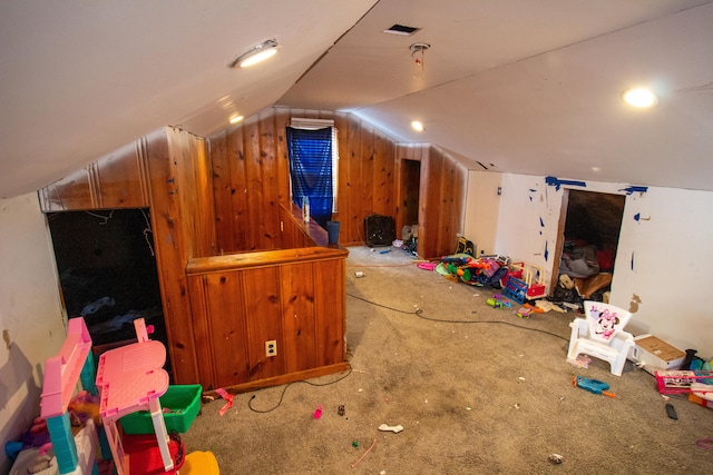 additional living space with wood walls, carpet floors, and lofted ceiling