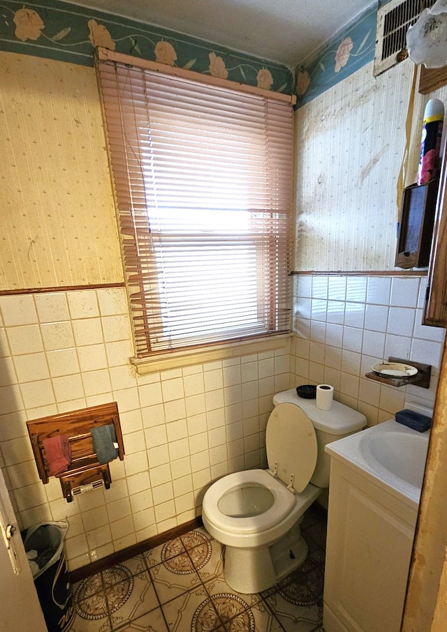 bathroom with tile patterned floors, vanity, tile walls, and toilet