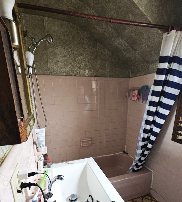 bathroom featuring shower / bath combination with curtain and tile walls