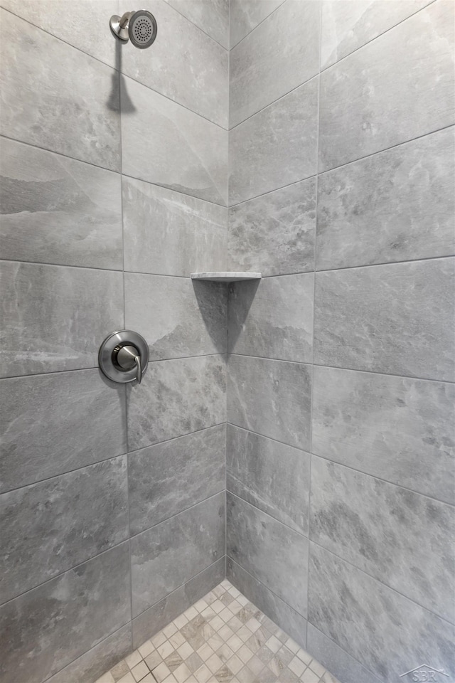 interior details with a tile shower