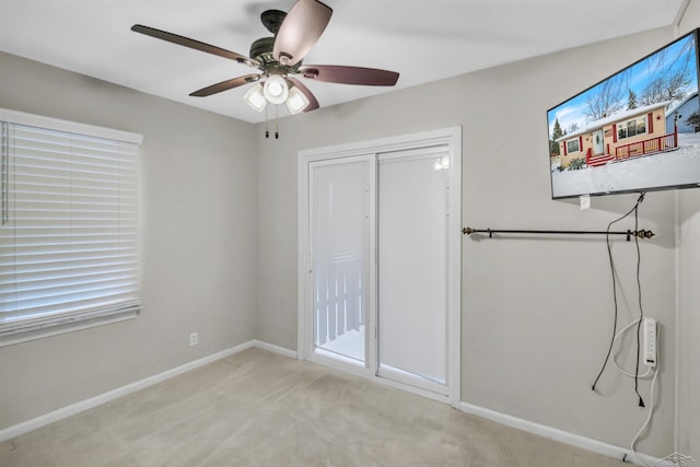 unfurnished bedroom with a closet, ceiling fan, and light colored carpet