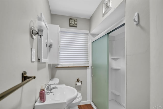 bathroom with toilet, walk in shower, and sink