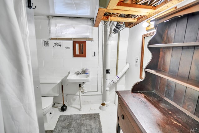 bathroom with toilet and concrete flooring