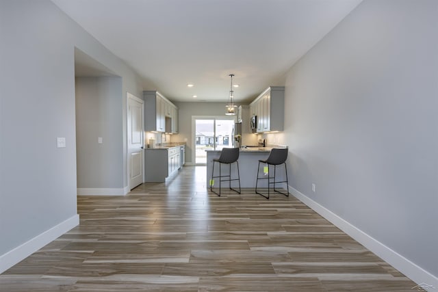 kitchen featuring a breakfast bar, light hardwood / wood-style floors, and appliances with stainless steel finishes