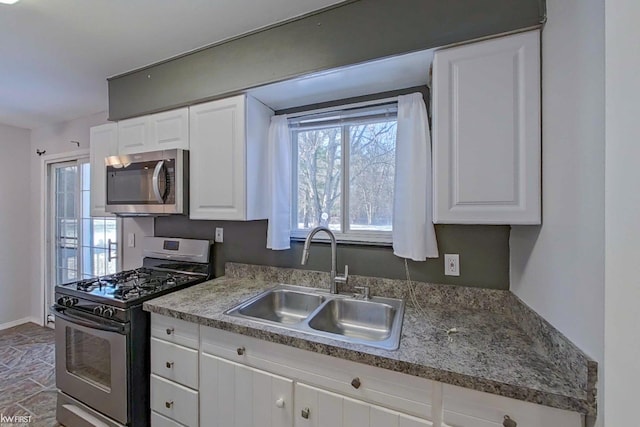 kitchen with sink, white cabinets, and appliances with stainless steel finishes