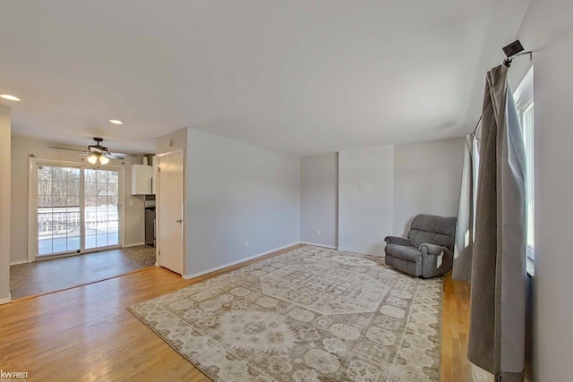 living area with light wood-type flooring and ceiling fan