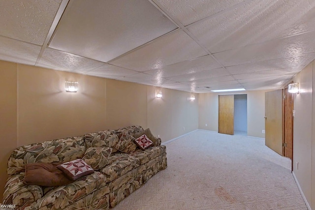 carpeted living room featuring a drop ceiling