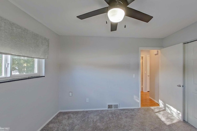 carpeted spare room featuring ceiling fan