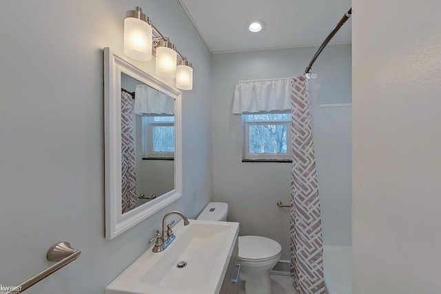 bathroom featuring sink, ornamental molding, and toilet