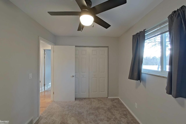 bedroom featuring ceiling fan, a closet, and light carpet