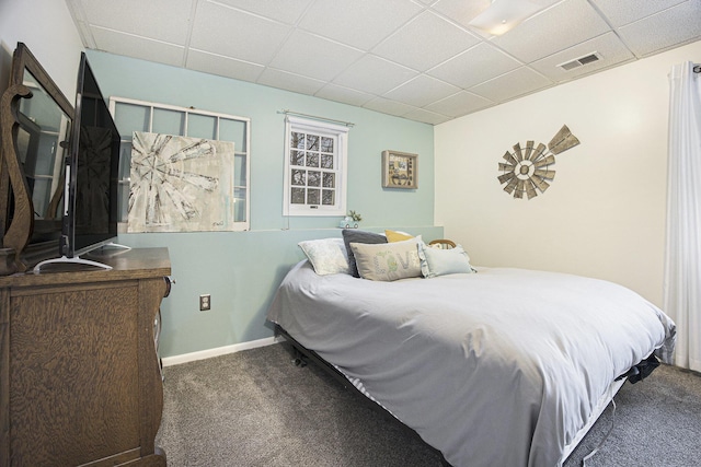 bedroom featuring a paneled ceiling and dark carpet