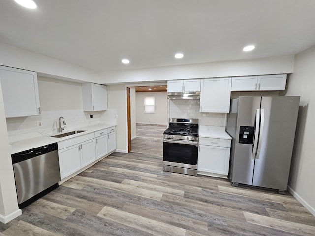 kitchen featuring white cabinets, appliances with stainless steel finishes, light wood-type flooring, and sink