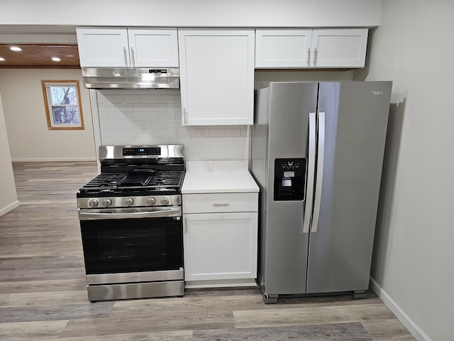 kitchen with white cabinets, light hardwood / wood-style flooring, stainless steel appliances, and tasteful backsplash