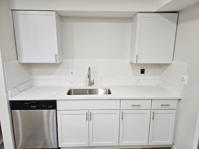 kitchen with backsplash, white cabinets, light stone counters, sink, and dishwasher