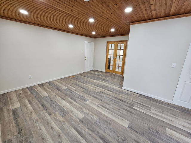 empty room with wood ceiling, crown molding, french doors, and wood-type flooring