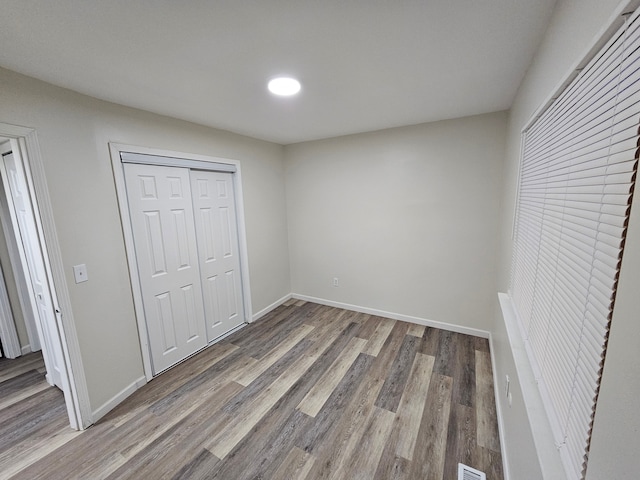 unfurnished bedroom featuring hardwood / wood-style flooring and a closet