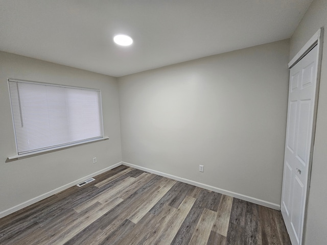 unfurnished bedroom with a closet and dark wood-type flooring