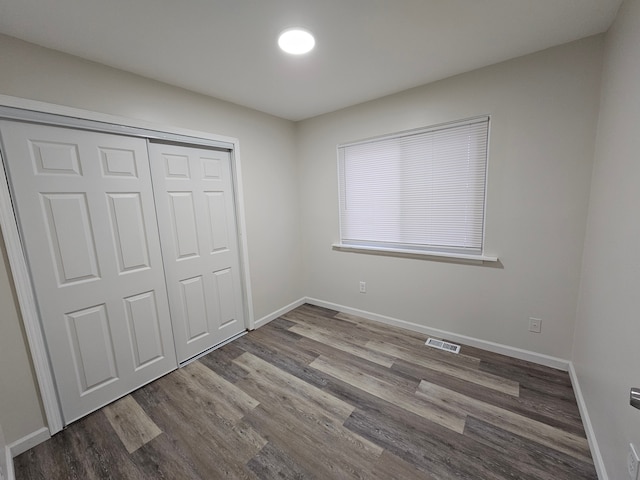 unfurnished bedroom with hardwood / wood-style floors and a closet