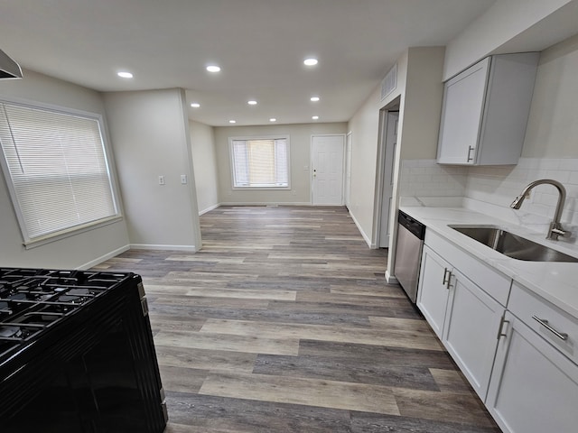 kitchen featuring light stone countertops, white cabinetry, stainless steel dishwasher, and sink