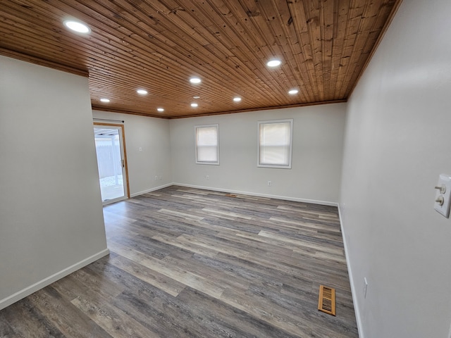 empty room with ornamental molding, dark hardwood / wood-style flooring, and wooden ceiling