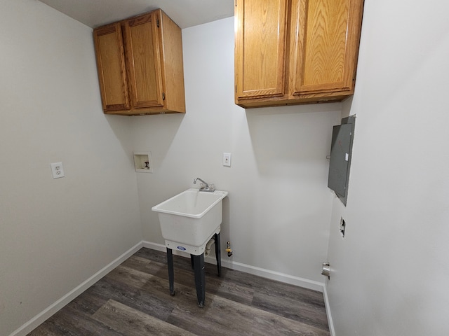 clothes washing area featuring electric panel, cabinets, dark wood-type flooring, and washer hookup