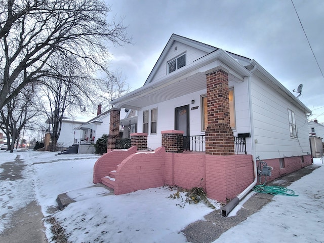 snow covered property featuring a porch