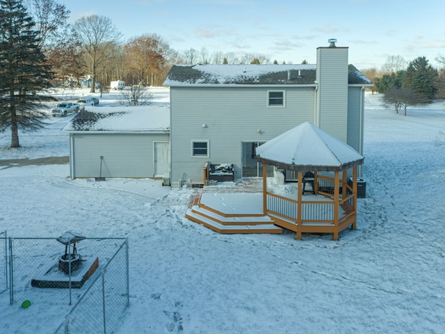 snow covered property with central AC unit and a deck