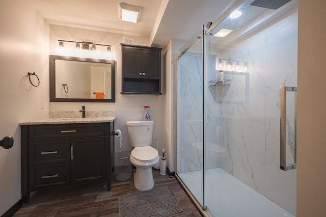 bathroom with vanity, hardwood / wood-style flooring, toilet, and a shower with door