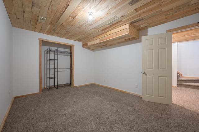 empty room with wooden ceiling and carpet floors